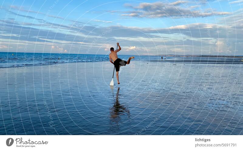 Jump of a paddler without a boat on the beach jump Paddle Beach wide younger