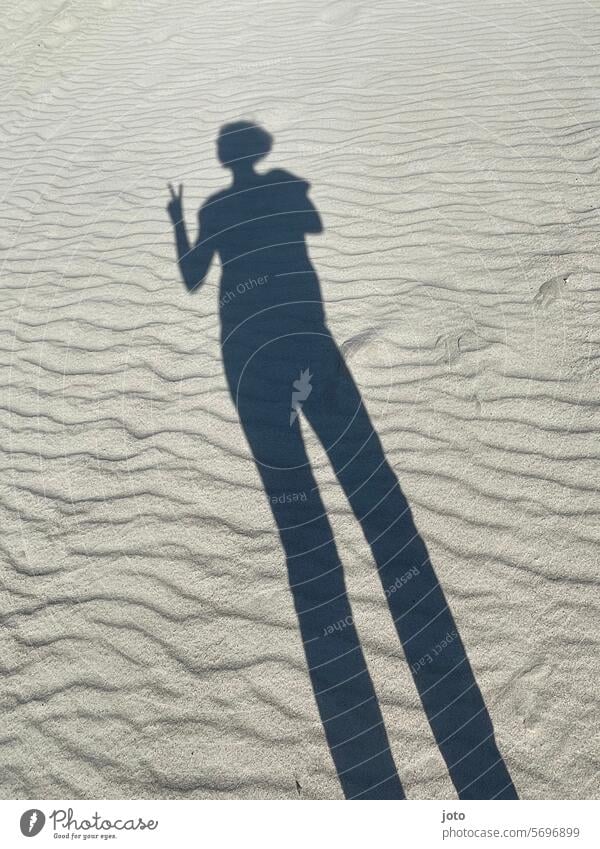 Silhouette of a person as a shadow on undulating sandy ground silhouettes Shadow shadow cast Shadow image Shadow play Contrast Light and shadow