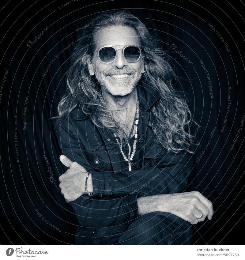 portrait of an elderly man with long hair and sunglasses Man 60 years long hairs Hippie Laughter smilingly kind Sunglasses happy necklaces Jewellery