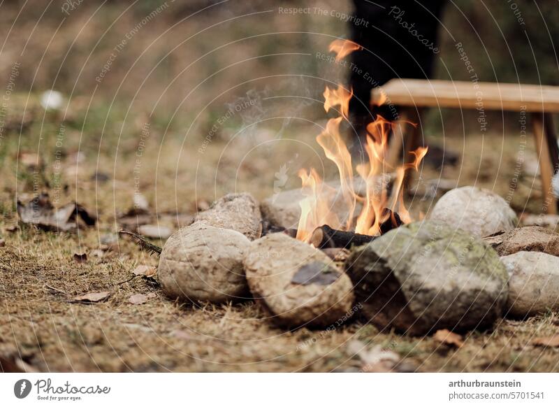 Campfire with dry wood in a stone circle in nature campfire Camp fire atmosphere Stone stones Meadow Nature Experiencing nature Love of nature Fire Fireplace