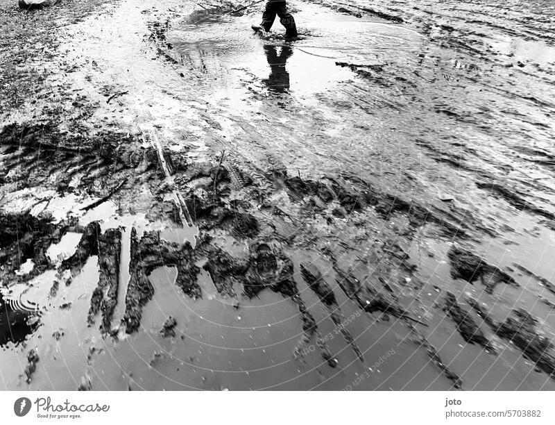 Reflection of a child in a puddle on a rainy day Puddle reflection Reflection in the water rainy weather Autumn Autumnal autumn atmosphere Black & white photo