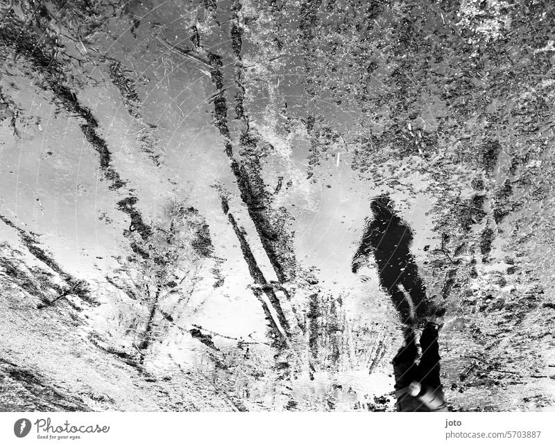 Reflection of a child in a puddle on a rainy day Puddle reflection Reflection in the water rainy weather Autumn Autumnal autumn atmosphere Black & white photo