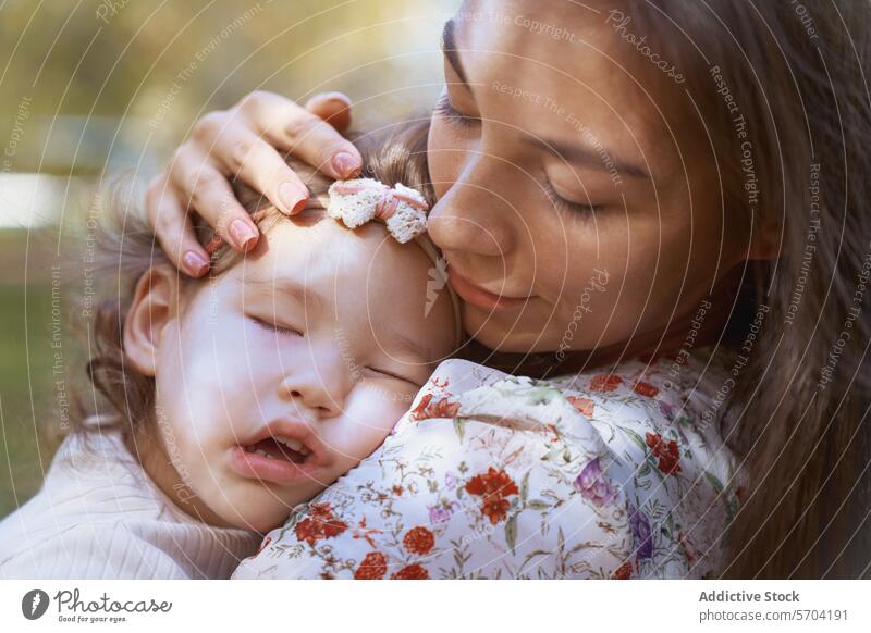 Ethnic mother and daughter bonding in California park nature california usa ethnic family love affection tenderness sleepy child woman embrace hug closeness