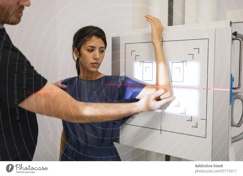 Patient undergoing a digital wrist x-ray examination patient technician scan medical facility healthcare assistance positioning technology radiology imaging
