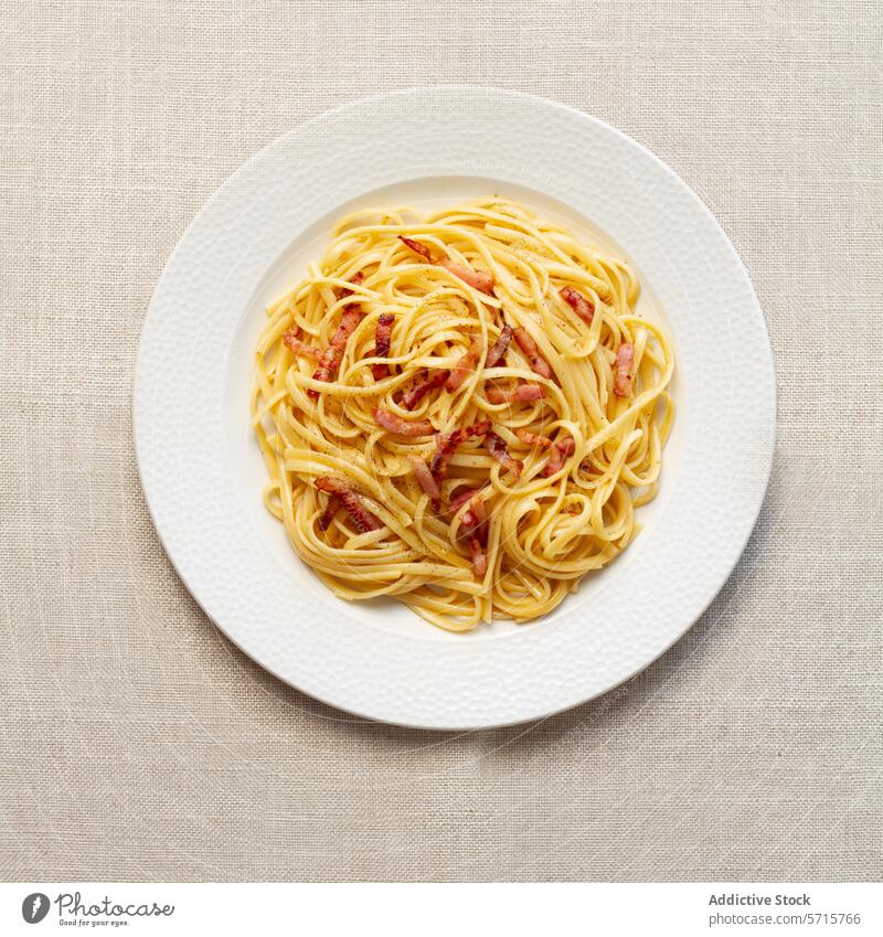 Classic Spaghetti Carbonara on White Plate spaghetti carbonara pasta italian cuisine traditional plate white neutral tablecloth top view food dish meal bacon