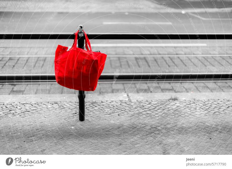 Red bag on the roadside Bag Pouch Hang Street Forget demarcation Fence Lanes & trails Barrier Border Traffic infrastructure Town Cobblestones Sidewalk Line off