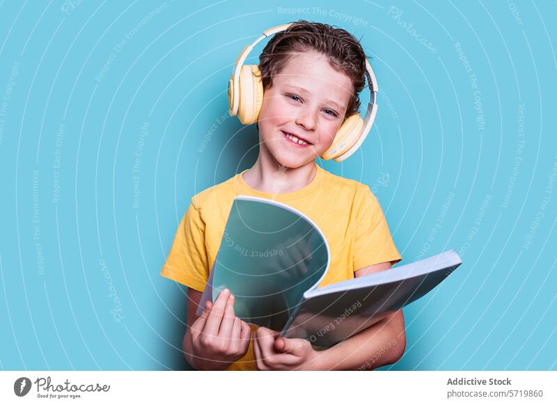 A charming boy in a yellow shirt with headphones enjoys reading a book, showcasing a blend of education and technology school child student learning engaging