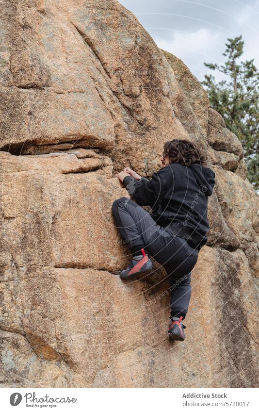 Focused climber makes their way up a steep cliff, demonstrating skill and concentration amidst a natural landscape solo ascending rugged bouldering outdoor