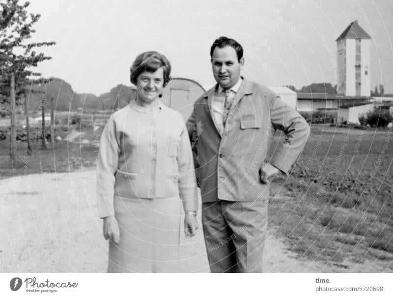 Man without tripod and camera, but with wife, and still on a dirt road Landscape Field acre Horizon Outskirts Tower Architecture Jacket Looking into the camera