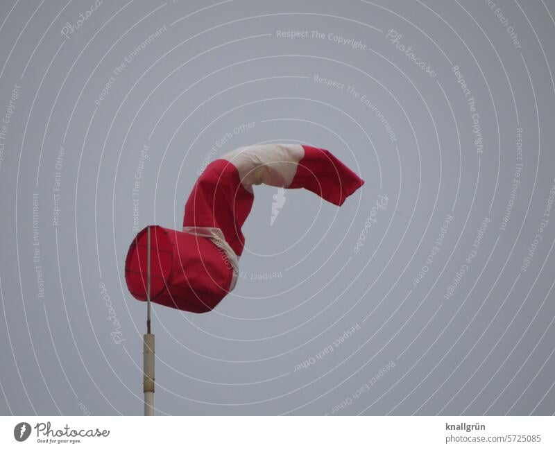 The air's out. Windsock Air Weather Calm Sky grey sky mild breeze Wind direction Exterior shot Wind speed Striped Climate Clouds Red Blow White Deserted