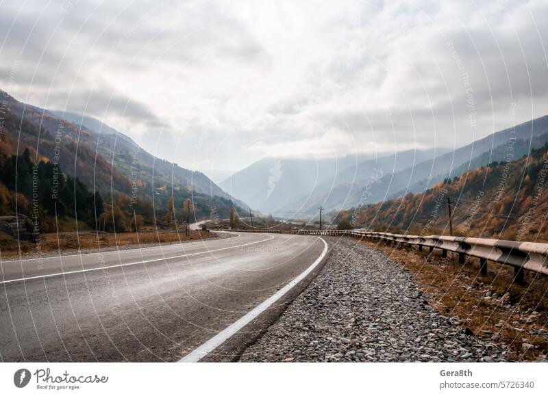 background mountain road and sky with clouds in the afternoon in Georgia Caucasus Sakartwell asphalt autumn cloudy day deserted fog haze hill landscape light