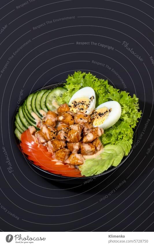 Salad bowl with chicken breast, rice, tomatoes, cucumbers and avocado Boiled egg salad Greek vegetables dressing vitamins health arugula spinach salmon food