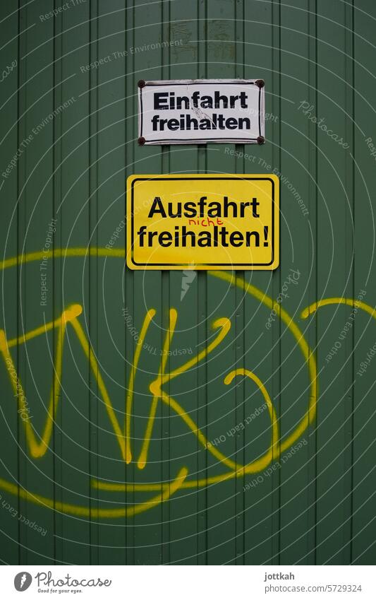 Green garage door with two signs Garage Germany Signs Highway ramp (entrance) Highway ramp (exit) Graffiti fool square keep Clearway Parking Yellow Disagreement