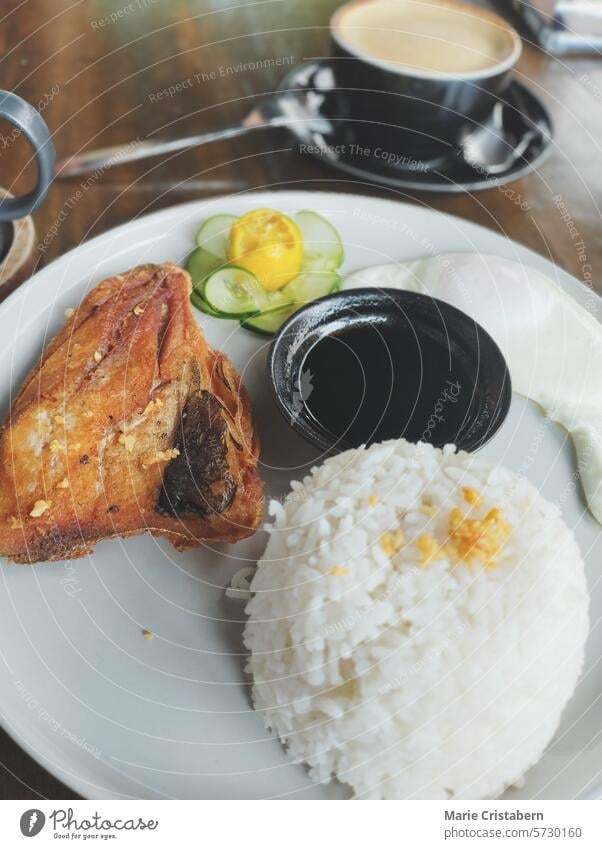 A traditional Filipino breakfast meal featuring fried marinated bangus, rice and egg that is collectively called bangsilog filipino food fish philippines