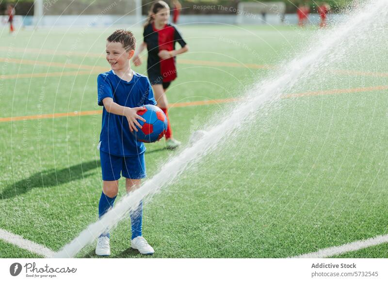 Young boy playing soccer in the rain on field sportswear ball wet water droplets young outdoor activity fun grass game child leisure happy joy smile youth