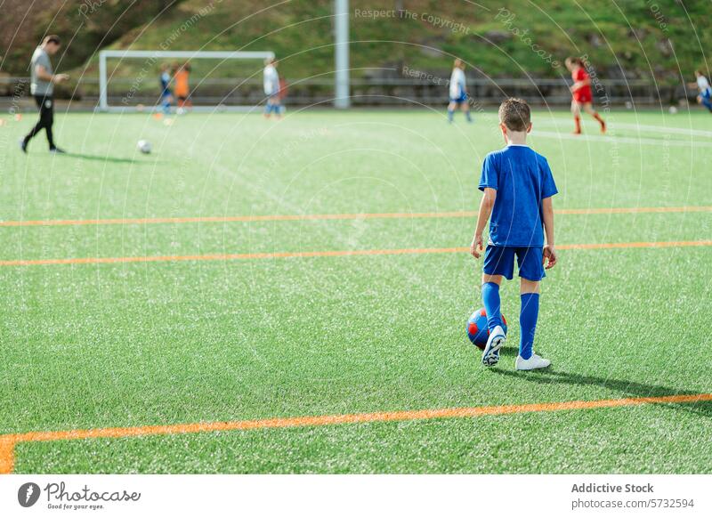 Young soccer player on field during a game young athlete uniform blue soccer ball green team sport youth match competition outdoor grass child active fitness