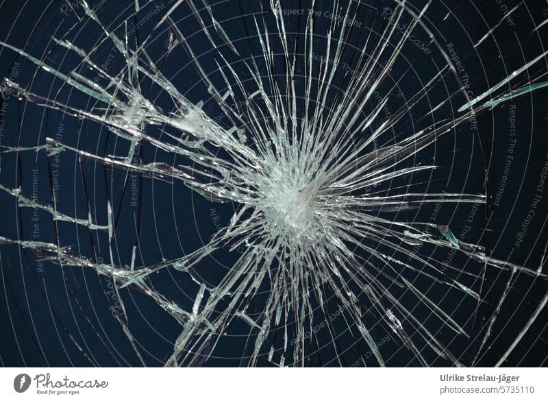 Glass pane shattered by an impact Pane fragmented Slivered cracks dark blue Broken Window pane Destruction Vandalism Transience Structures and shapes