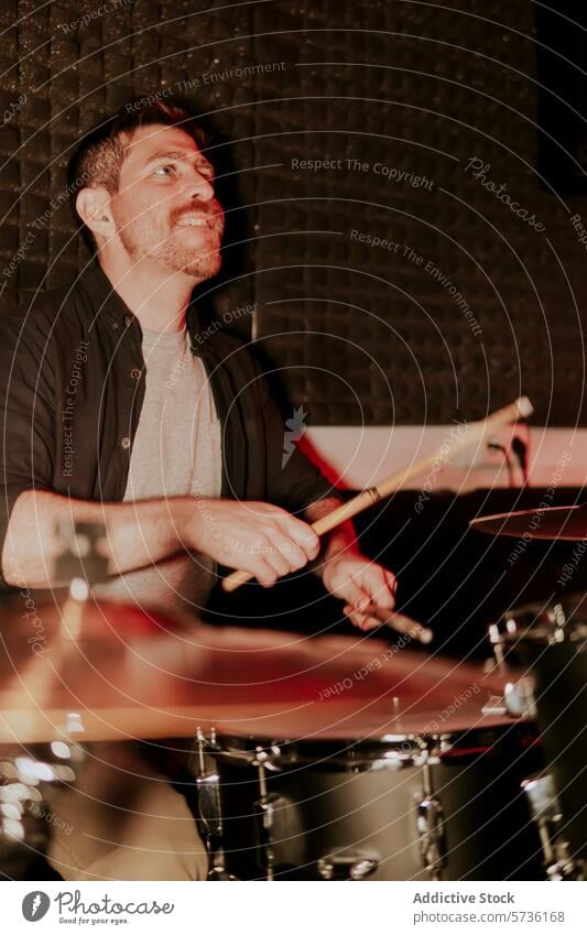 Enthusiastic male drummer playing in dim setting man performance drum kit sticks music band musician instrument entertainment focused enthusiasm looking away