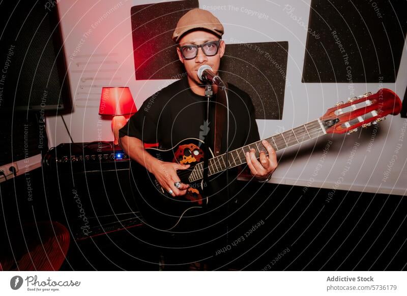 Male guitarist singing and playing in a studio setting man male music band singer microphone instrument acoustic performance cap entertainment musician