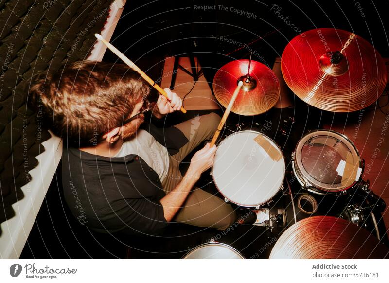 Male drummer playing in a music band setting male man performance cymbal drumstick instrument percussion rhythm beat musician focus concentrated kit practice