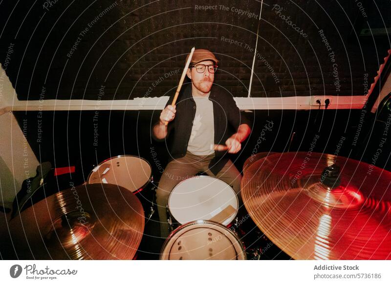 Passionate male drummer playing in a dark room drum set man music band instrument passion intensity action sticks performance rhythm beat musician cymbal snare