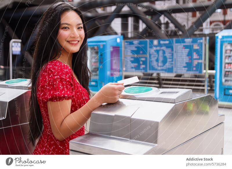 Smiling woman using public transport system looking at camera side view smiling ticket turnstile access dress red city travel commuter passenger transportation