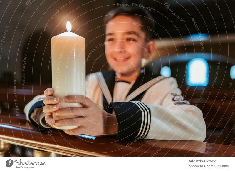 A smiling boy in his First Communion outfit holds a candle with a bright flame, symbolizing joy and faith in the church joyful holding communion smile