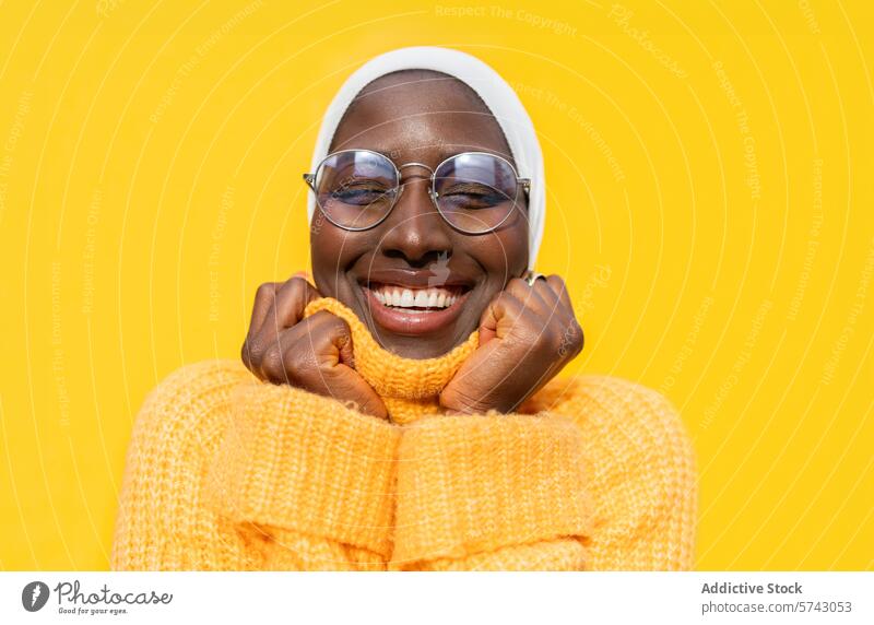 Cheerful African American woman in vibrant yellow female african american happiness joyful cheerful sweater hijab bright fashion style clothing comfort smiling