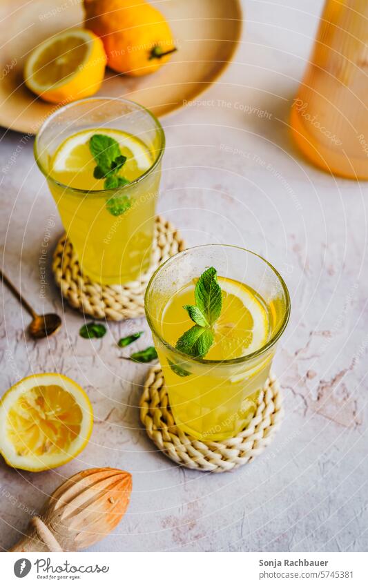 Refreshing drink with lemon in two glasses Beverage Lemon Refreshment Juice Cold Summer Fresh Glass Lemonade Drinking Citrus fruits Slice Mint Leaf Fruit
