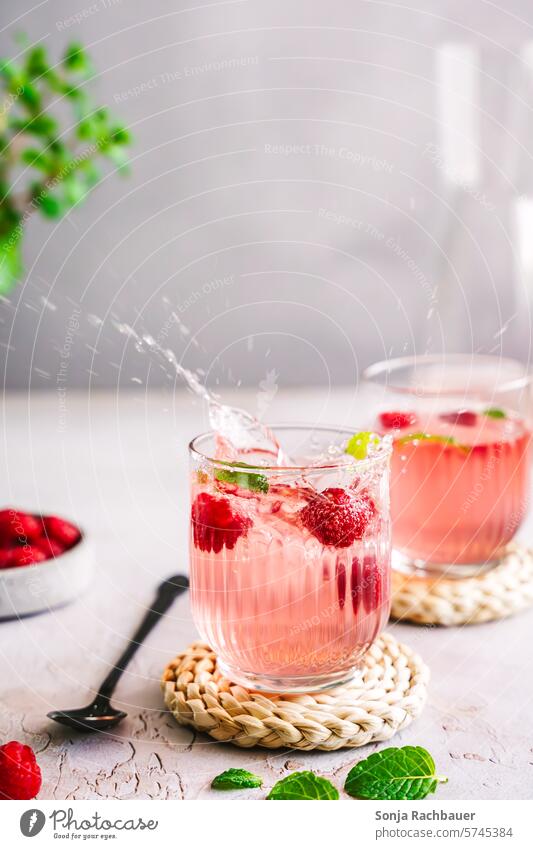 Sparkling summer drink with raspberries in two glasses. Beverage Raspberry Cold drink Effervescent Cocktail Summer cute Lemonade Longdrink Glass Fresh