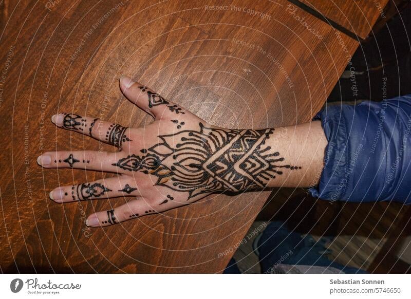 Female hand with a black henna tatoo with wooden background human tattoo love isolated arm finger care skin woman people open moroccan concept symbol gesture