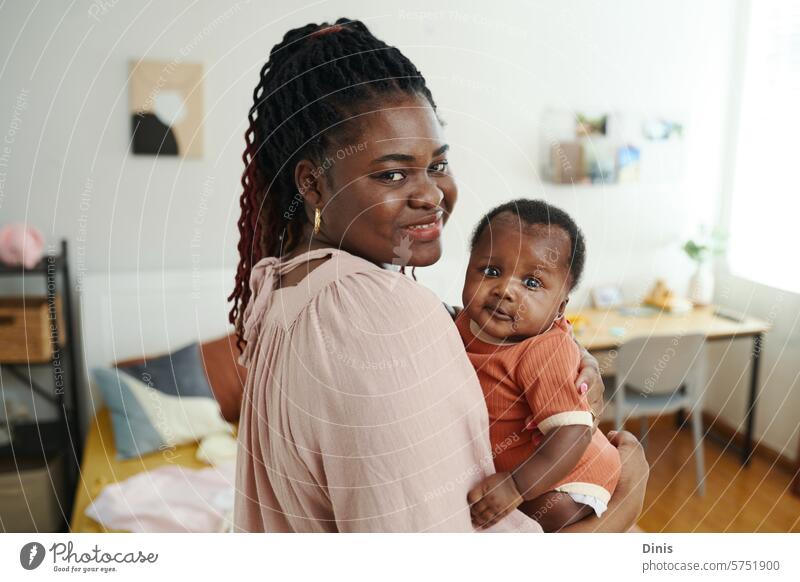 Portrait of Black woman with little baby in hands standing in bedroom Black baby newborn Baby girl infant home childhood small innocent motherhood parenthood