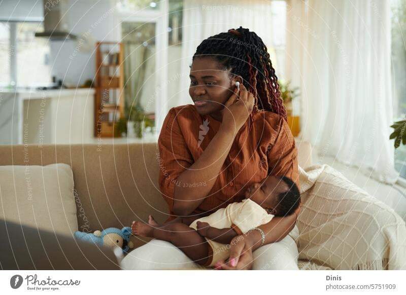 Black woman using earbuds to watch educational video when her baby is sleeping Video learn study mother kid Baby motherhood happy rocking child care parenthood