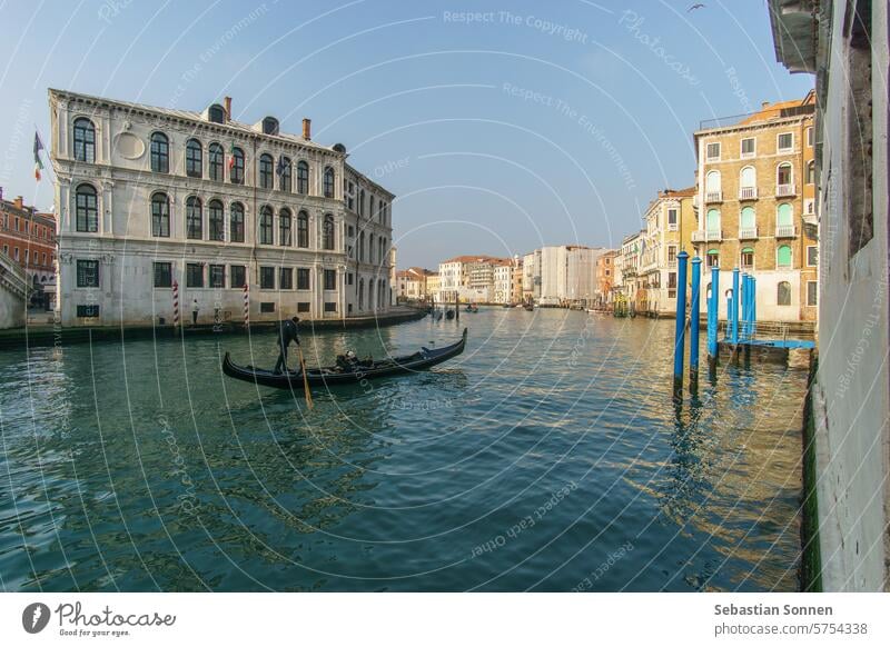 A gondola boat on the Canal Grande on a sunny winter day in front of typical building facades, Venice, Veneto, Italy tourism grand canal venice travel tourist