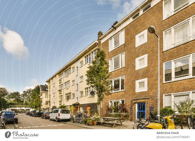 Quiet residential street with apartment buildings and parked cars bicycle sunny peaceful modern urban housing facade window door brick vehicle transport