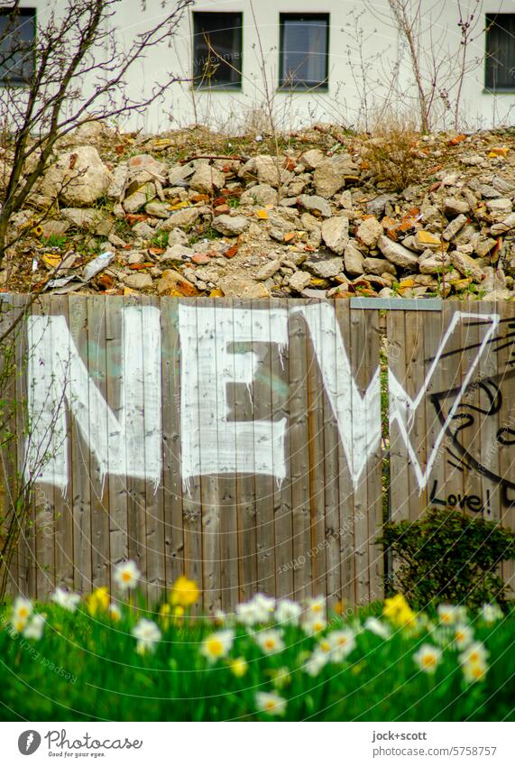 NEW - New building, pile of rubble, construction fence and spring flowers Hoarding Street art Spray Graffiti Wall (building) English Trash heap Characters Word