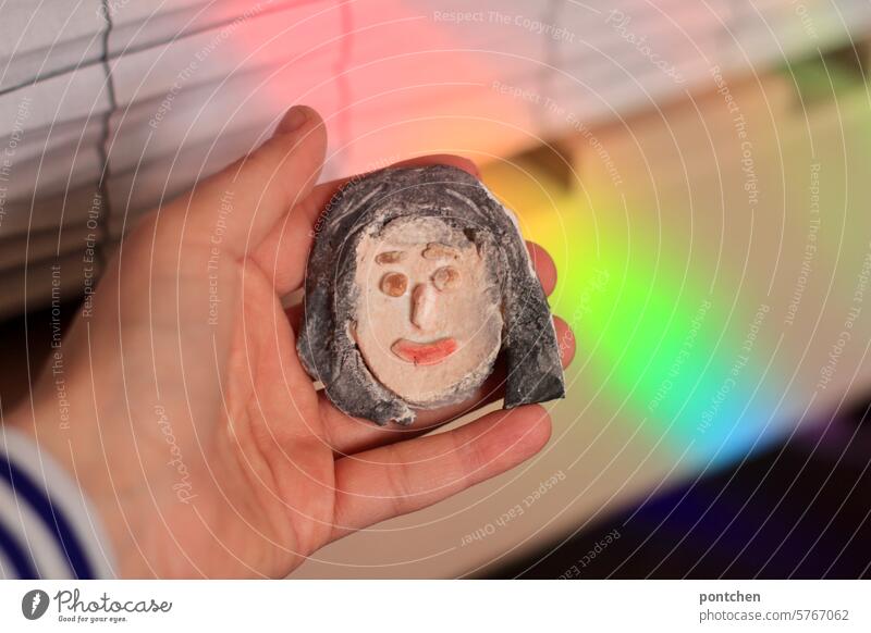 one person holds a female face made of salt dough. Face Alter ego Equal Creativity Handicraft empathize Human being Interior shot Colour photo Rainbow