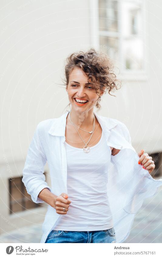 young girl walking on the old streets of europe hairstyle brown empty alone stone walls fashionable joy counting emotions glasses bright day clothes jeans