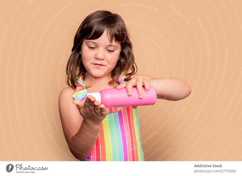 Curious Girl with Pink Water Bottle girl water bottle pink curiosity child examine dress stripe colorful smile young hold interest beverage hydration kid