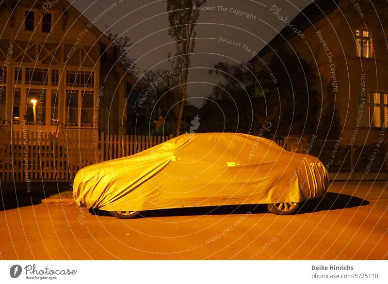 Car under the sleeping cap or cover in the golden lantern light. car hood Sleeping cap evening hour evening mood Bedtime Covers (Construction) Slumber