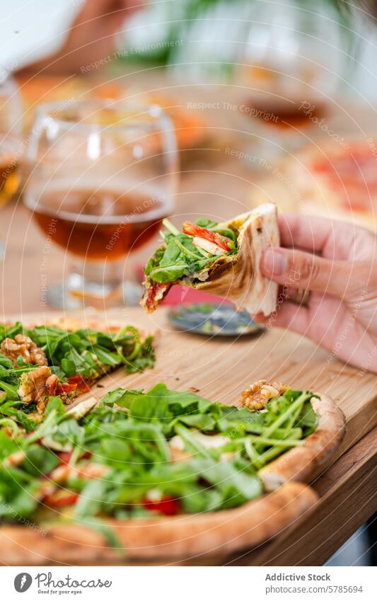 Toasting with Gluten-Free Beer and Gourmet Pizza person toasting gluten-free beer gourmet pizza arugula nuts serrano ham wooden table hand alcohol beverage