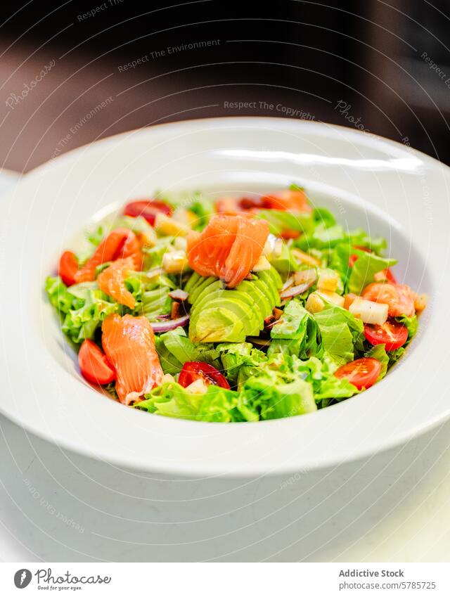 Fresh house salad with salmon, cherry tomatoes, and avocado mezclum onion apple fresh bowl white vibrant succulent ripe crisp juicy creamy food healthy meal