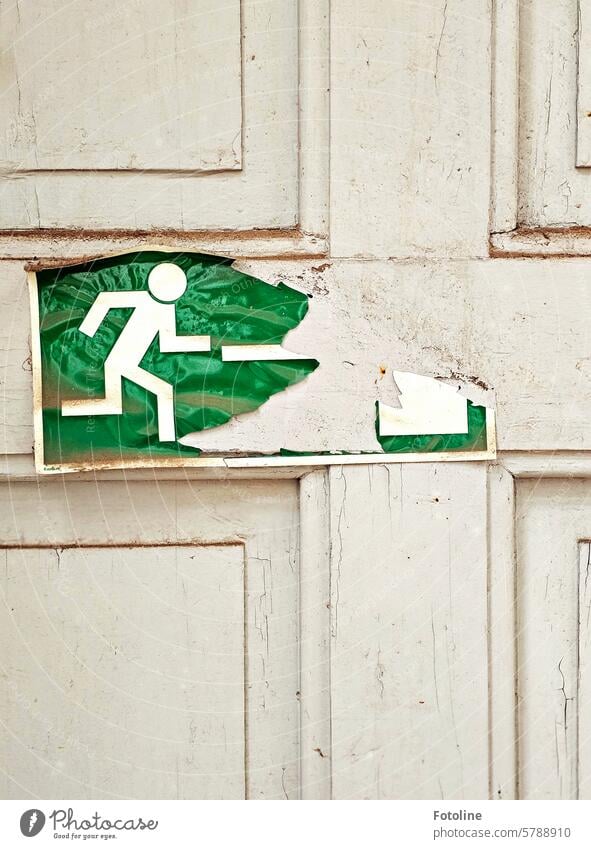 The emergency exit sign on the wooden door has also seen better days. Emergency exit Safety Escape route Signs and labeling Signage Exit route Rescue Green