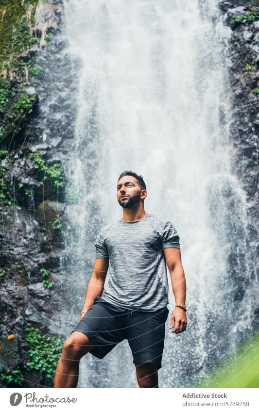 Man standing in front of a waterfall in Costa Rica man costa rica nature travel contemplative lush landscape majestic outdoor adventure tropical serene