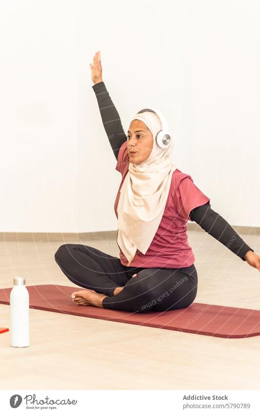 Muslim woman practicing yoga in comfortable attire muslim pose ardha matsyendrasana seated twist hijab sportswear wellness health exercise tranquility