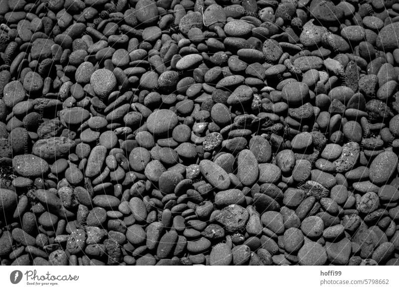 many black round polished flat stones on the beach of Lanzarote Gray Round Many Pebble Pebble beach Abstract Minimalistic cut glass Ground down Black stones