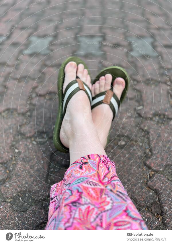 Feet with flip-flops raise one's feet Flip-flops variegated Paving stone rest Break Summer Legs Relaxation To enjoy Vacation & Travel Human being Woman Barefoot