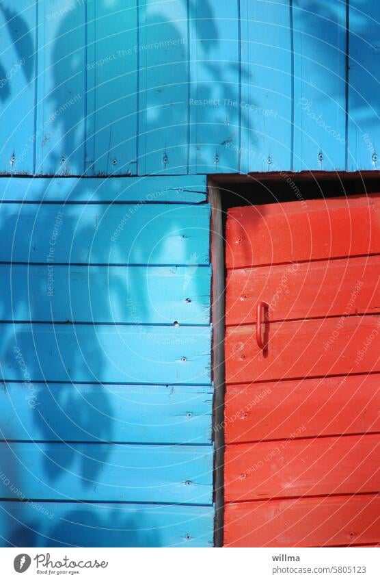 Closed, unadapted and then even shadowed Arbour Blue Red door slanting Wood shack Wooden house Wooden arbor
