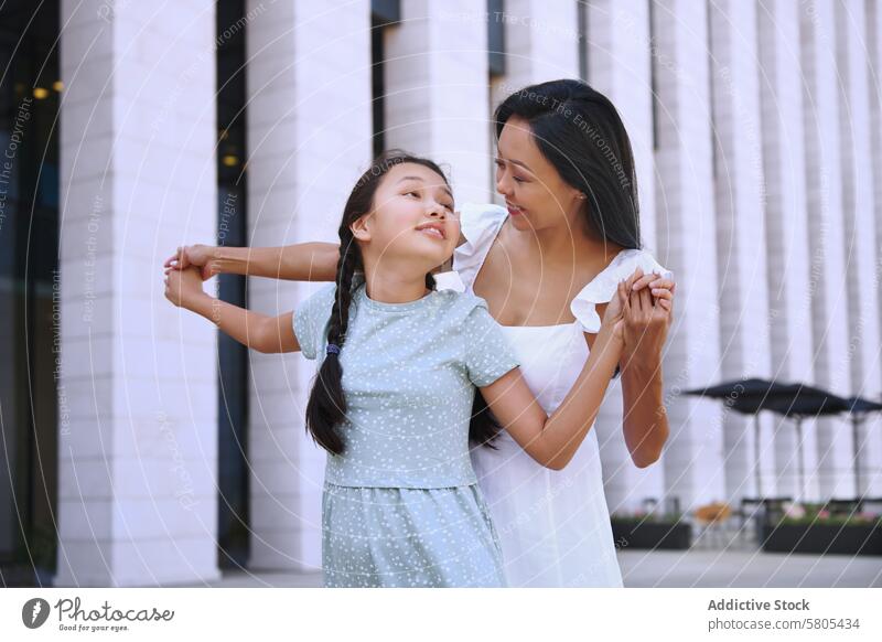 Girl with autism spectrum dancing with her mother while walking in the city Woman female daughter child person with autism ADHD neurodiversity childhood kid