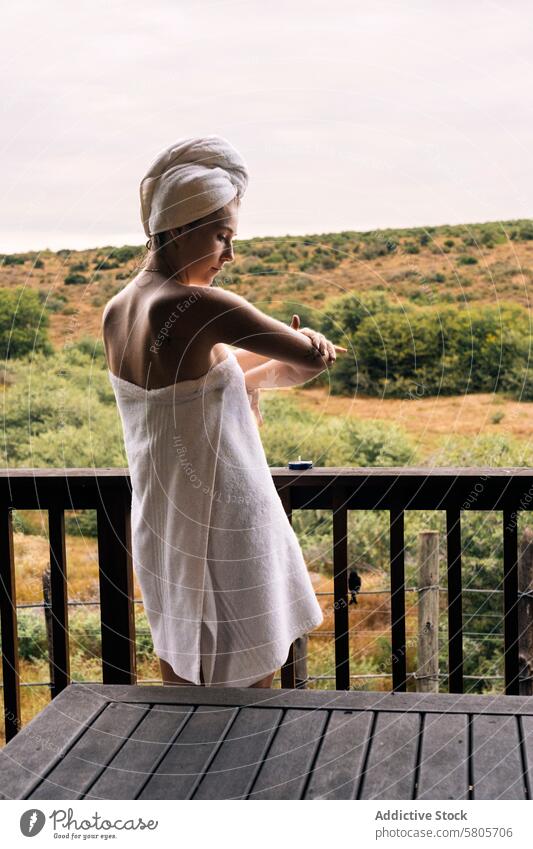 Woman relaxing on balcony with nature view woman towel relaxation tranquility wooden looking away thoughtful peaceful natural landscape outdoor serene leisure